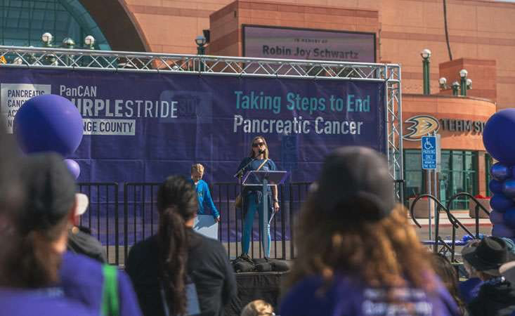 An Advocate addresses crowd at PANCAN’s PurpleStride. The organization’s success in securing millions in funding is a model of hope.