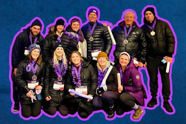 A group poses, holding glow sticks, smiling radiating hope against pancreatic cancer.