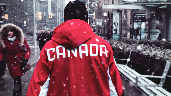 A man with a red sweater braces the winter to push forward.